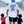 Man wearing a white t-shirt with text, holding hands with two children on a sidewalk.